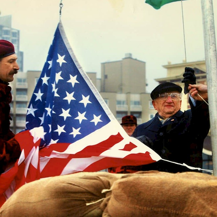 Ben raises a U.S. flag at the Hague, March 2003
